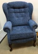 A Sherbourne Upholstery Limited blue chenille covered buttoned wing back scroll armchair on