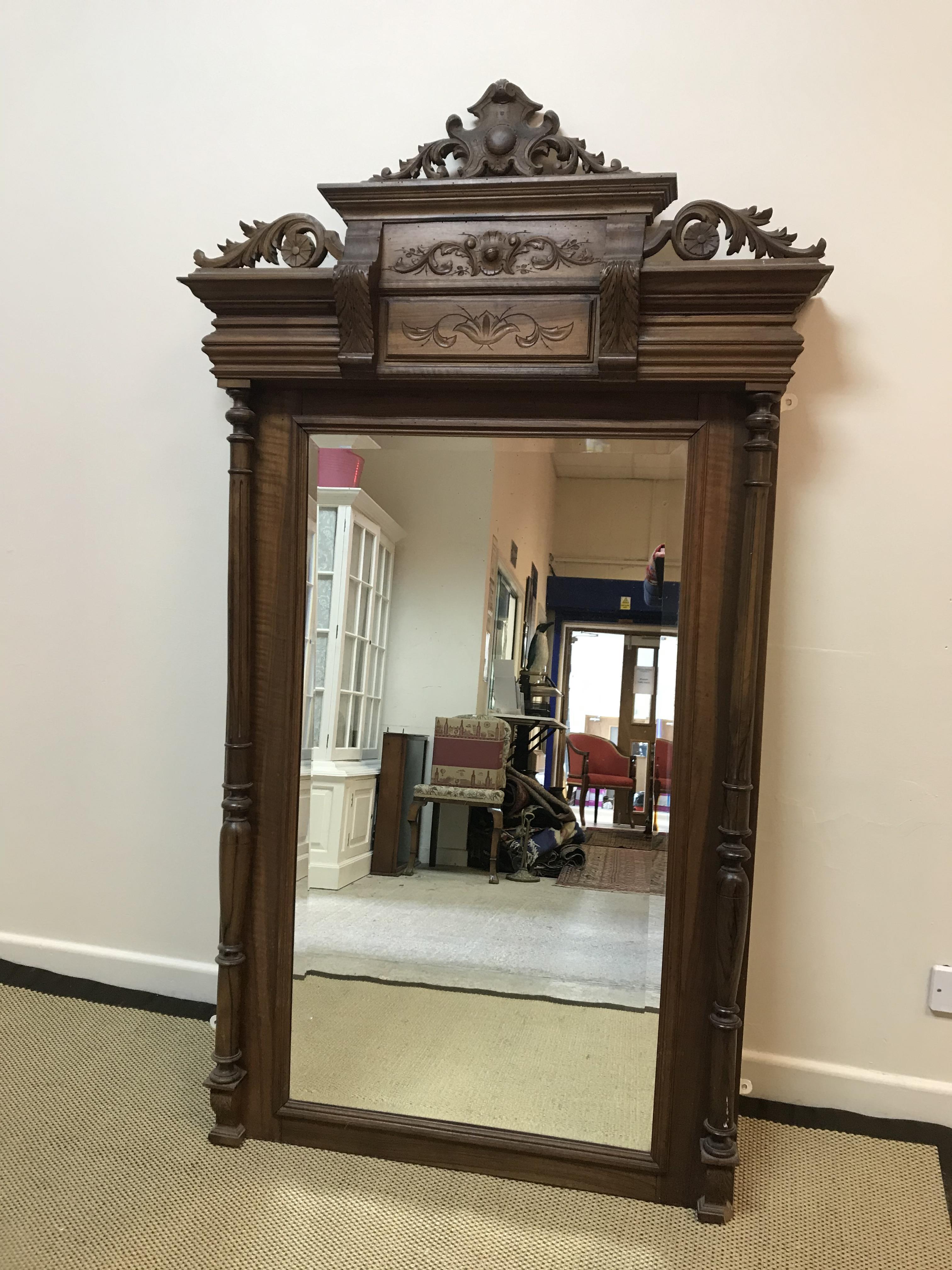 A mahogany framed pier glass with ornate foliate and floral decorated surmount over a rectangular