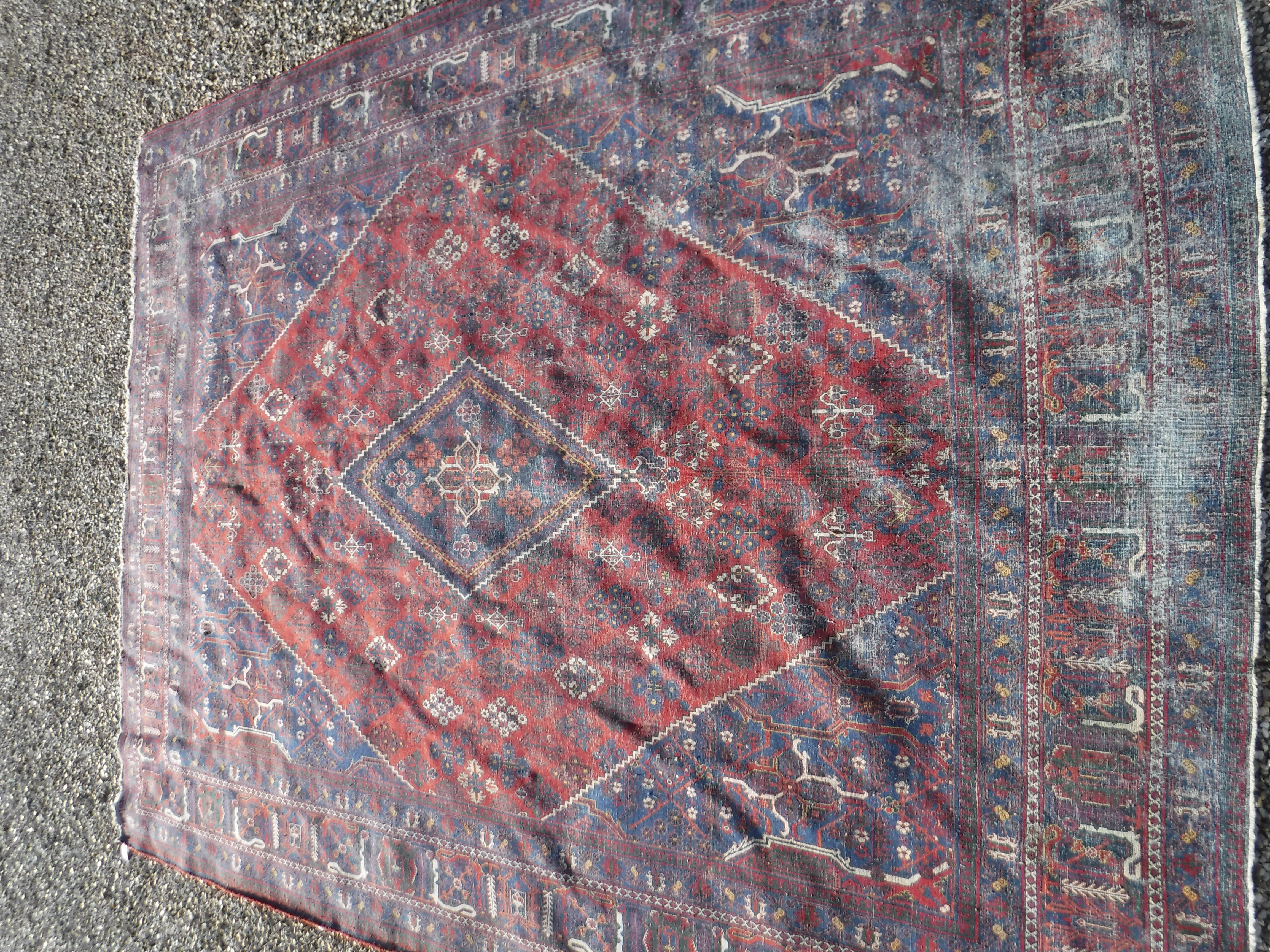 A Persian rug with all over floral decoration on a red ground, - Image 3 of 5