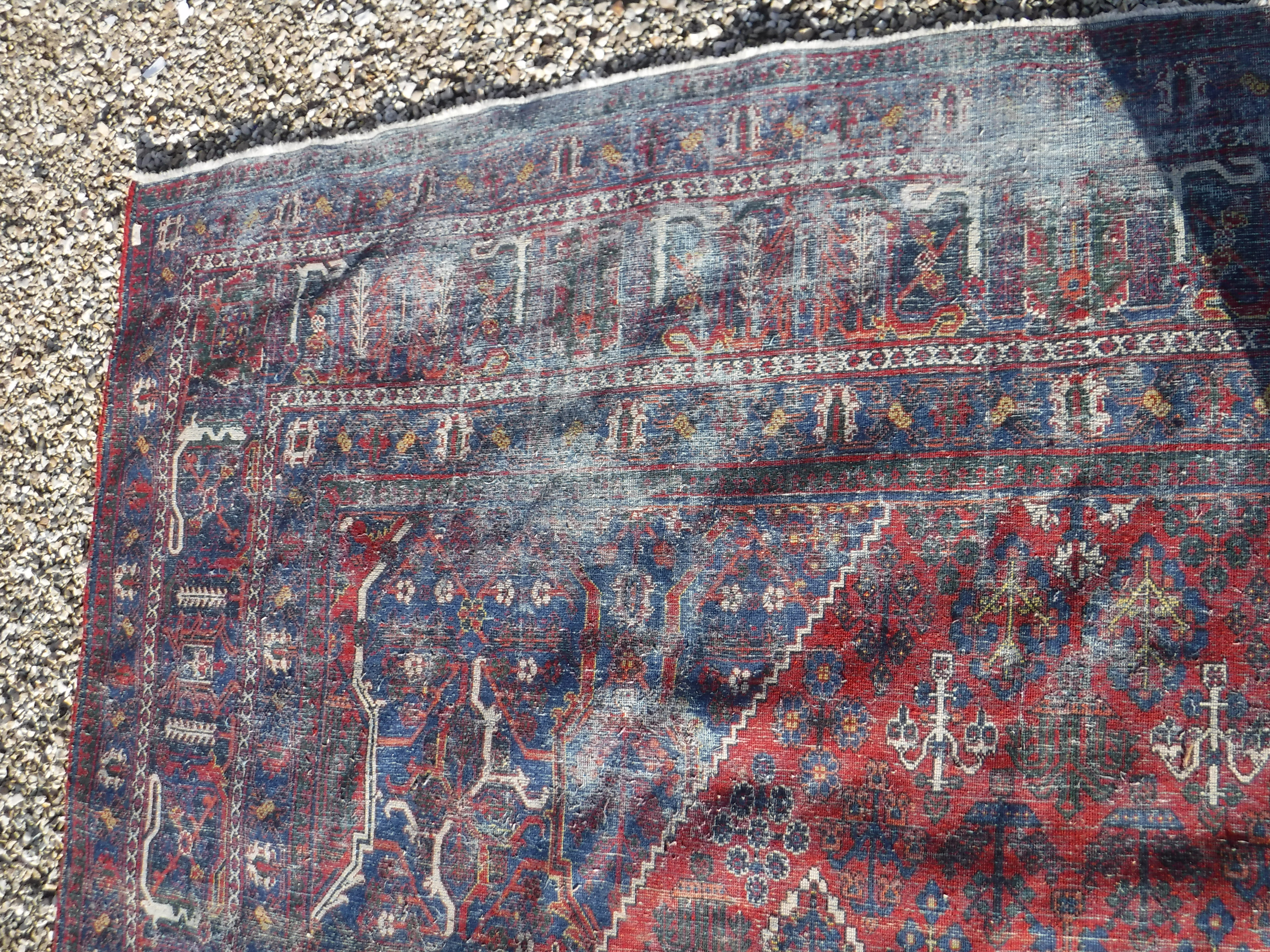A Persian rug with all over floral decoration on a red ground, - Image 4 of 5