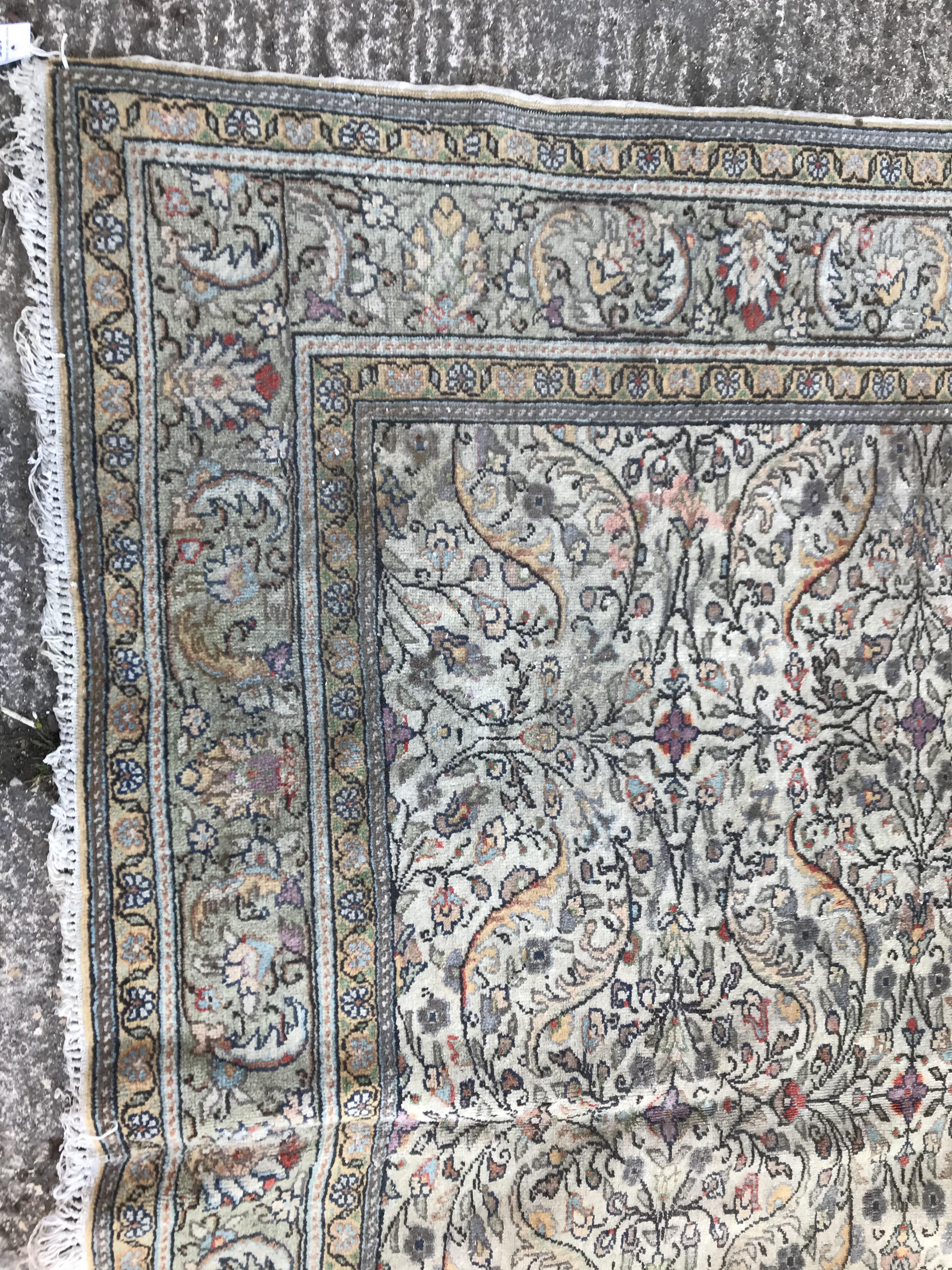 An Oriental carpet, the central panel set with all over floral decoration on a fawn ground, - Image 2 of 11
