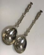 A pair of Continental silver seal top Apostle spoons with ornate scrollwork engraved handles and