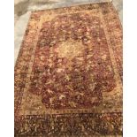 An early 20th Century Agra North India carpet with centre medallion on a wine-coloured ground,