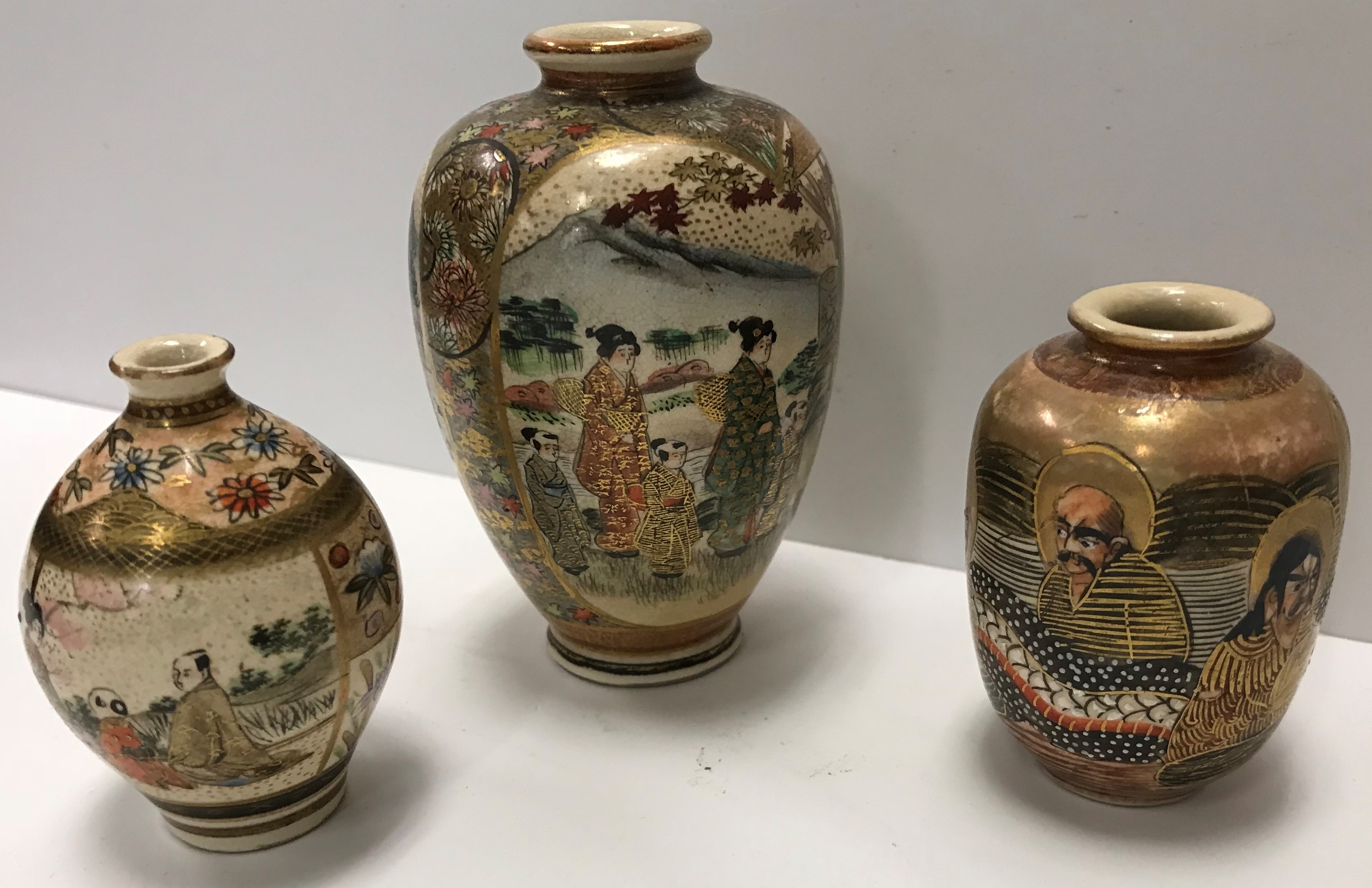 A collection of three various miniature Satsuma vases decorated with figures and floral motifs,