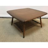 An Ercol elm coffee table of rounded square form on turned legs united by a magazine rack undertier,