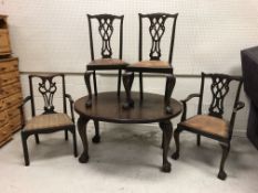 An early 20th Century mahogany oval dining table on foliate carved cabriole legs to claw and ball