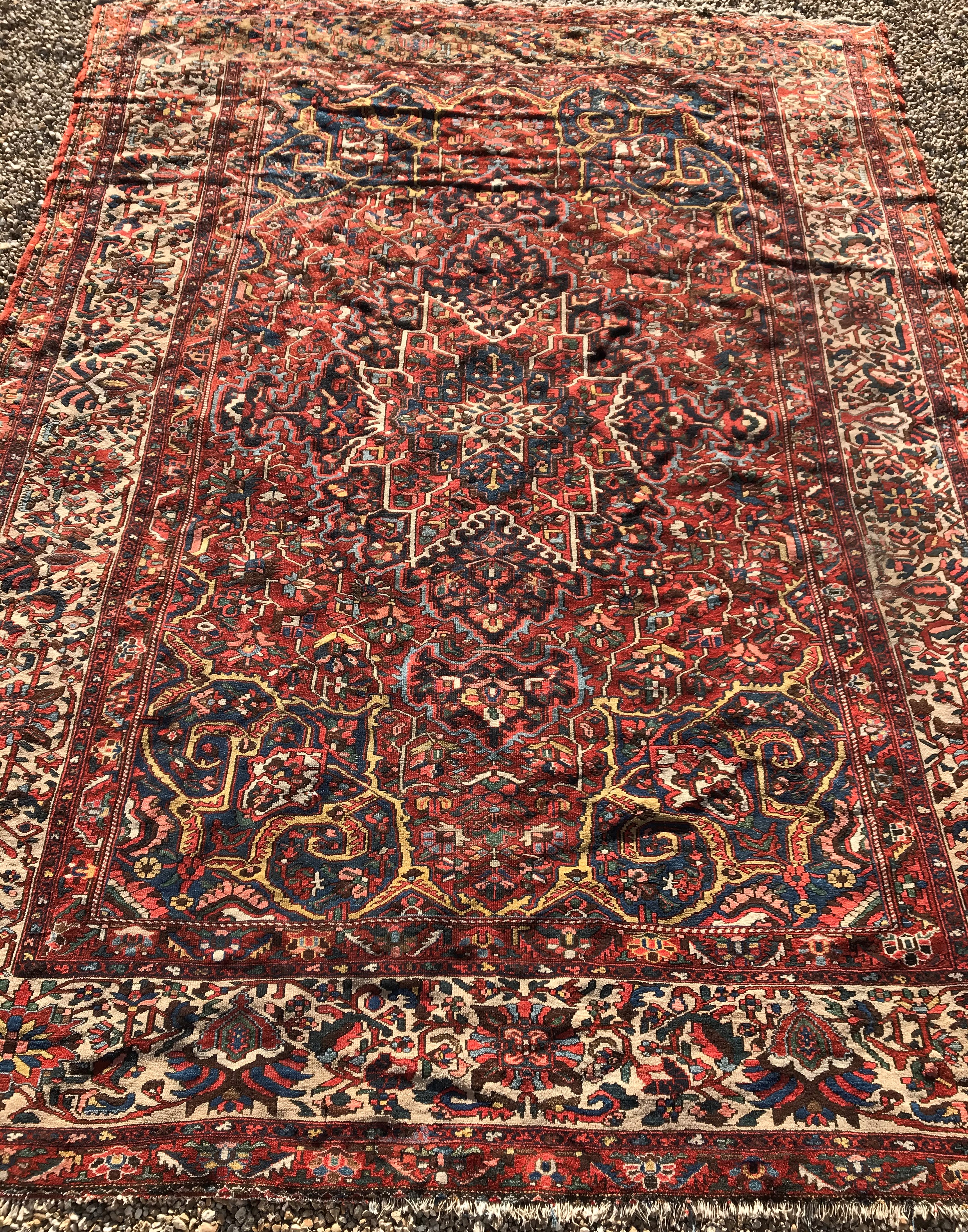 A Persian rug with centre medallion on a red ground and all over floral decoration within a cream