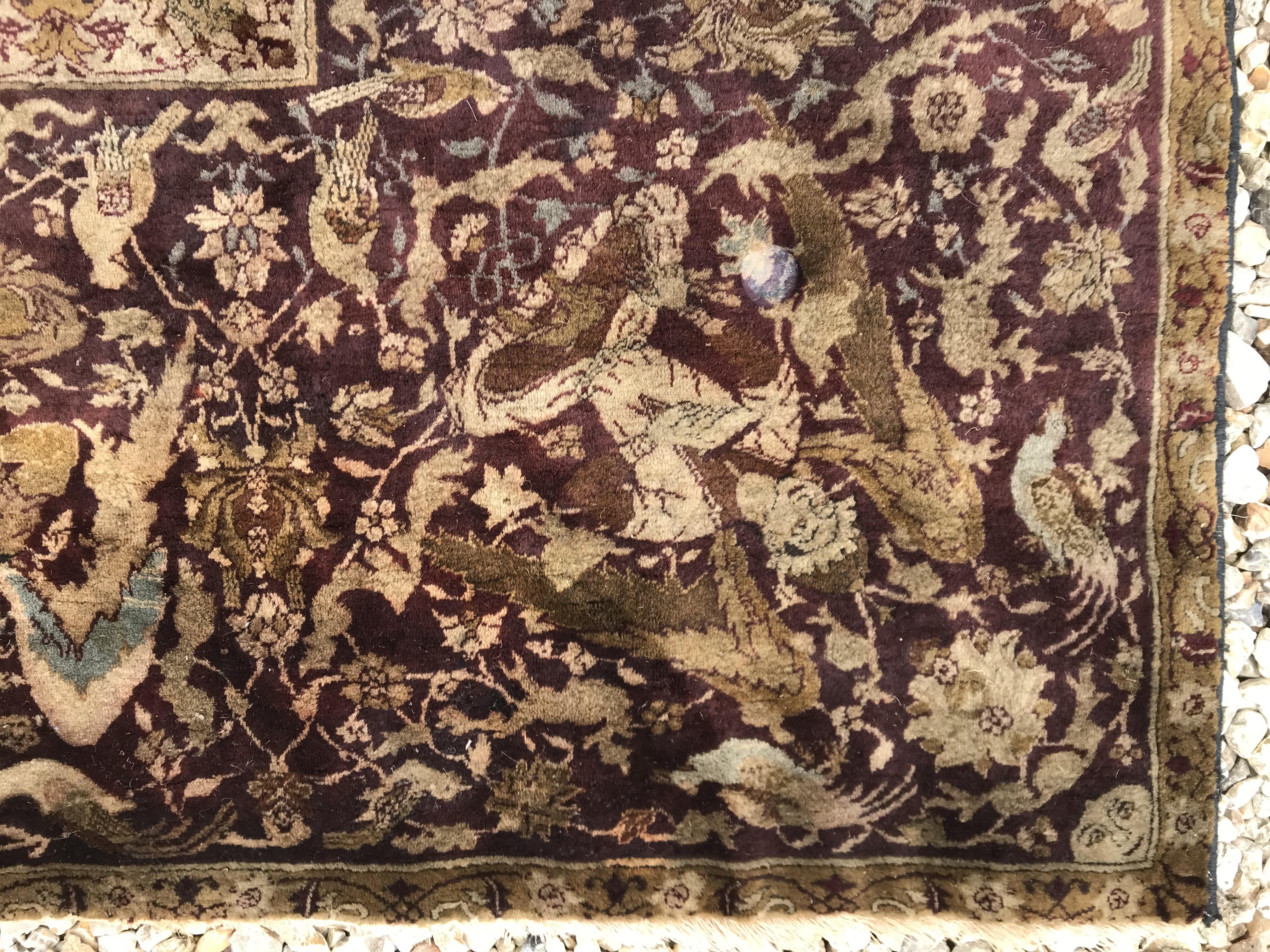 An early 20th Century Agra North India carpet with centre medallion on a wine-coloured ground, - Image 11 of 103