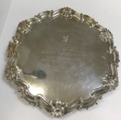 A late Victorian silver salver in the Georgian style, with piecrust and shell decorated rim,