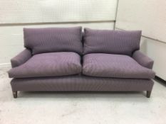 A modern mauve upholstered two seat sofa on square tapered legs,