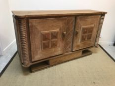 A 20th Century oak two-door sideboard with square panelled doors on centre pedestal base,