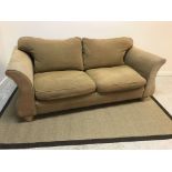 A modern fawn upholstered scroll arm two seat sofa on limed turned feet,