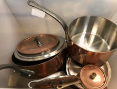 A box containing various copper pans and skillets, jelly moulds,