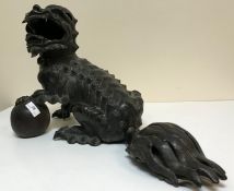 A 19th Century Chinese bronze censer as a temple lion, the paw upon a wooden ball,