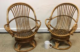 A pair of modern child's cane work swivel armchairs on circular bases, 42.