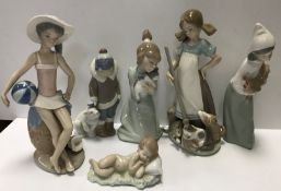 A collection of Lladro figurines to include "Girl holding cat", "Girl with broom and bucket,