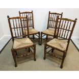 A set of four 20th Century oak rush seat spindle back dining chairs in the 19th Century North