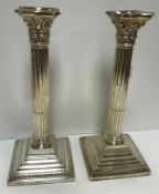 A pair of late Victorian silver Corinthian column candlesticks on stepped bases with beaded edge