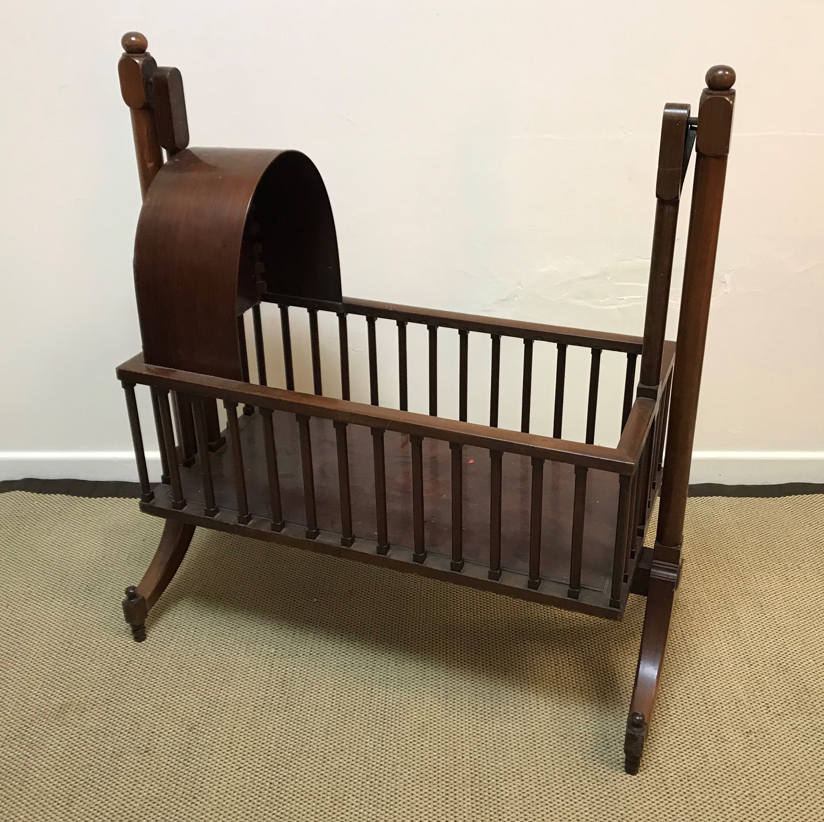 A modern mahogany crib in the Victorian style with domed hood and galleried sides,