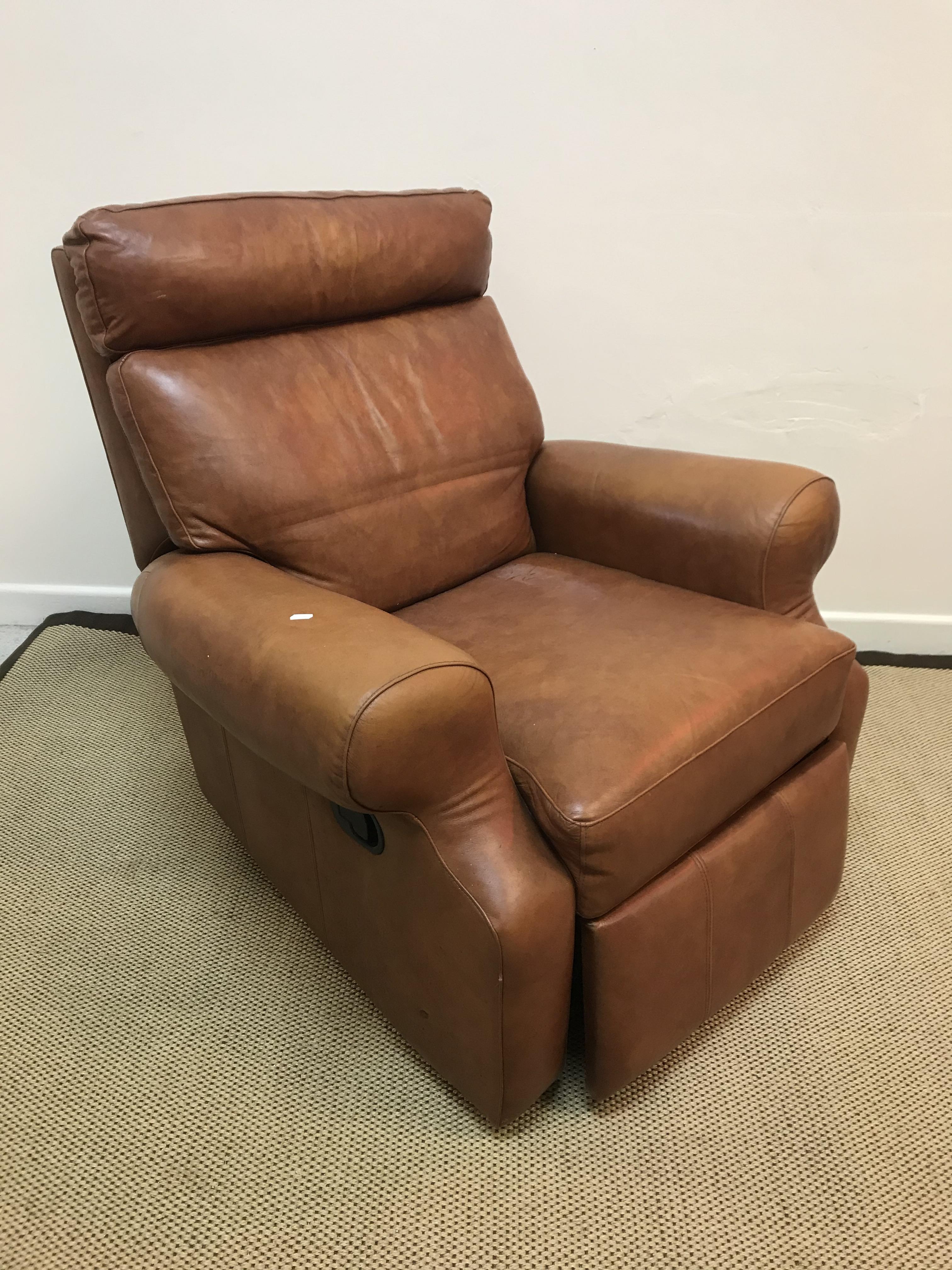 A mid brown leather upholstered scroll arm reclining armchair,