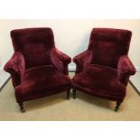 A pair of circa 1900 burgundy velour upholstered scroll arm chairs on ebonised baluster-turned