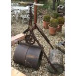 A Victorian cast iron garden roller with turned wooden handles,