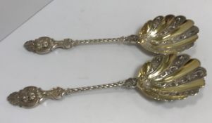 A pair of Victorian silver gilt spoons with cherubim mask handles and gilt-washed and embossed