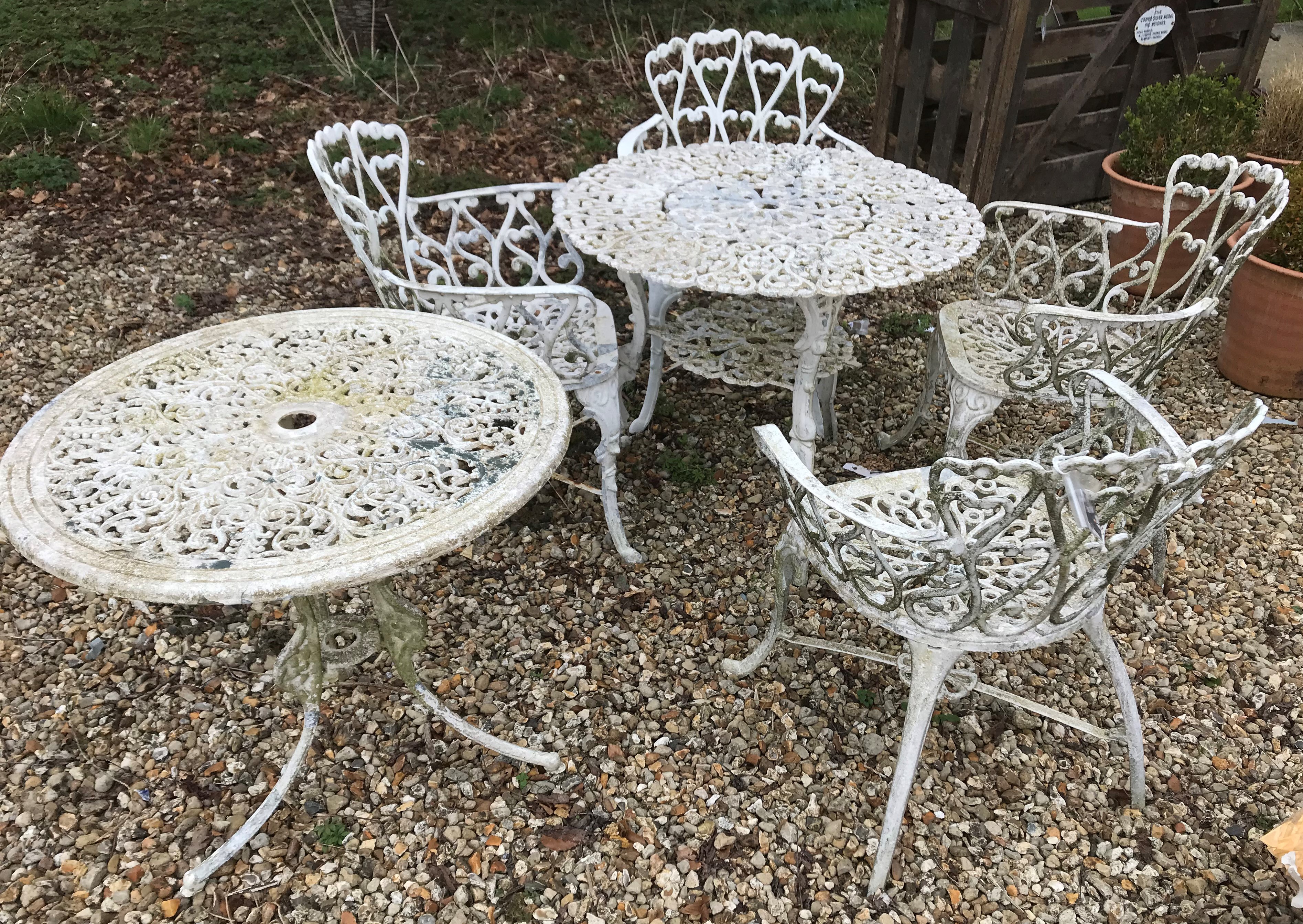 A modern painted metal circular garden table, the top with foliate design,