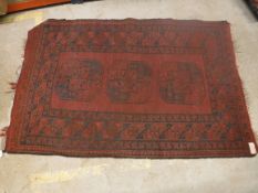 An Afghan rug, the central panel set wit