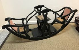 A Victorian ebonised child's rocking chair for three children,