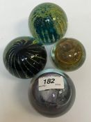 A Mdina coloured glass paperweight, an Isle of Wight coloured glass paperweight, two others similar,