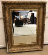 A circa 1900 giltwood and gesso framed rectangular wall mirror with acanthus and laurel leaf