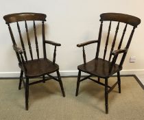 A pair of Victorian beech and elm stickback elbow chairs on turned and ringed legs united by