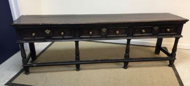 An 18th Century oak dresser, the plain plank top above three panelled drawers,