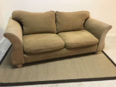 A modern fawn upholstered scroll arm two seat sofa on limed turned feet,