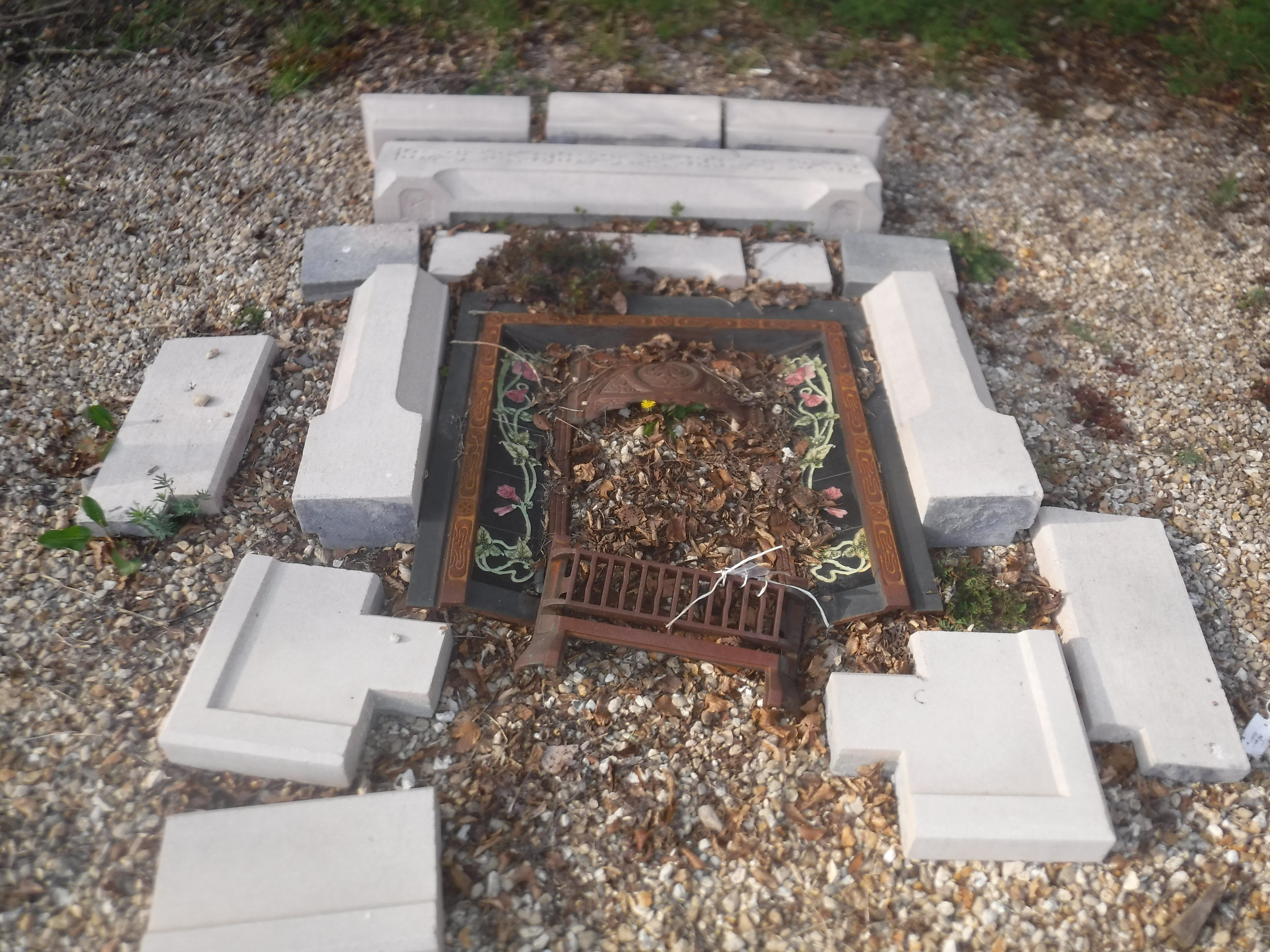 A cast iron fire place with concrete surround