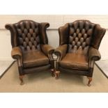 Two similar modern leather upholstered armchairs, each with buttoned back,