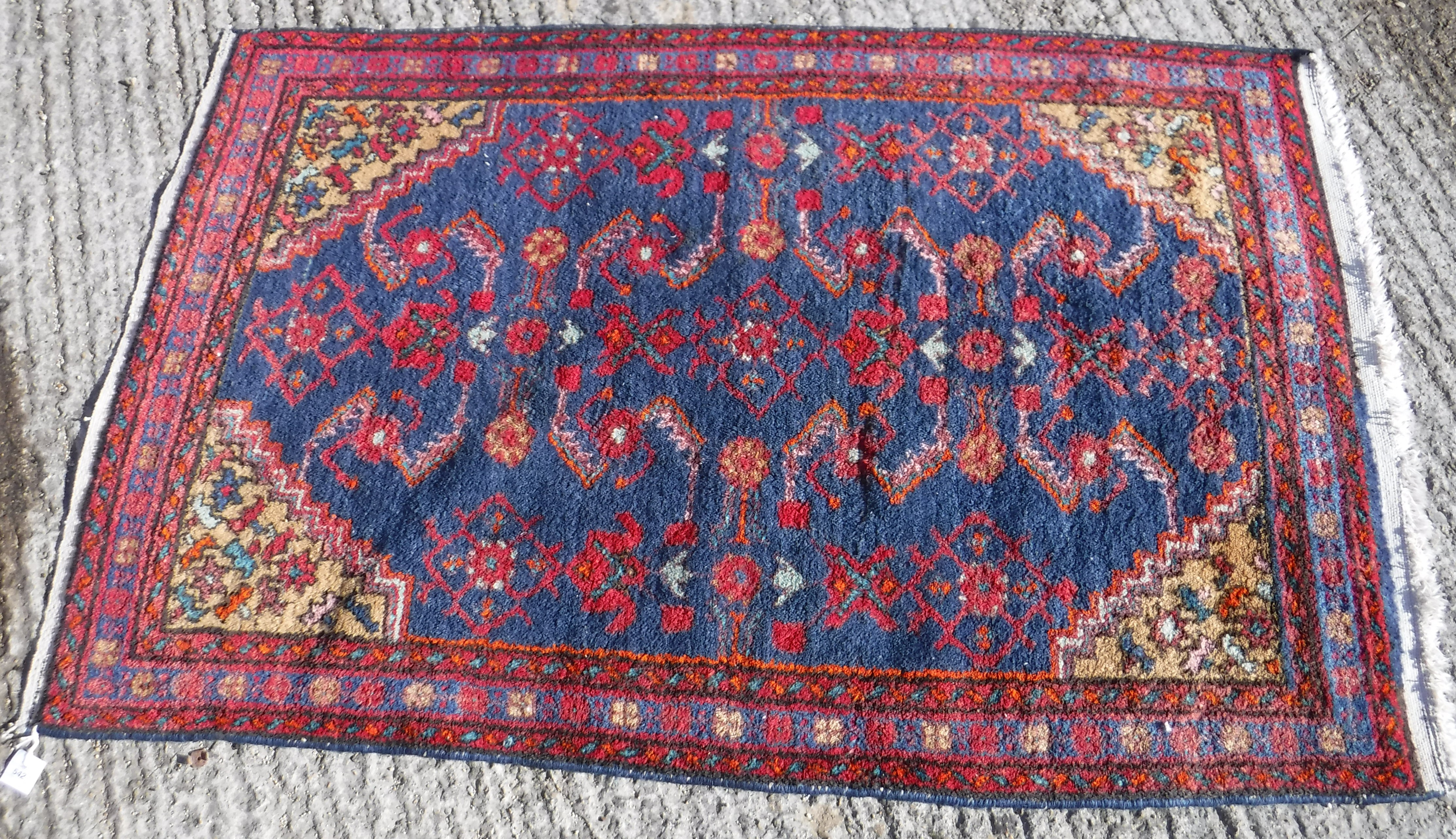 A Caucasian rug, the central panel set with stylised floral decoration on a blue ground,