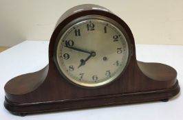 An early 20th Century mahogany cased mantel clock, the circular silvered dial with Arabic numerals,