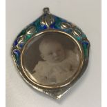 An Edwardian silver and enamel decorated pendant set with pendant locket (by William Hair Haseler,