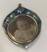 An Edwardian silver and enamel decorated pendant set with pendant locket (by William Hair Haseler,