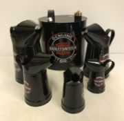 A set of five modern painted oil cans and an oval modern painted petrol can "Harley Davidson",