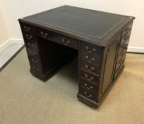 An Edwardian mahogany library desk, the plain top with leather insert above a kneehole,