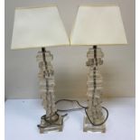 A pair of modern perspex candlesticks as piled books swivelling on a chrome style rod,