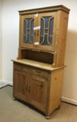 A pine dresser with two frosted glazed doors enclosing two shelves over a recess,