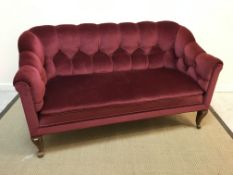 An early 20th Century two seat scroll arm settee, with red upholstery and cabriole legs,