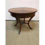 A modern walnut veneered circular centre table in the Empire taste on four splayed supports,