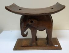 An African carved hardwood "elephant" stool on rectangular chamfered base,