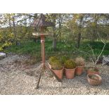 A wooden bird table, together with a set of five terracotta flared pots,