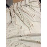 A pair of linen type cream ground lined curtains with gold thread detail,